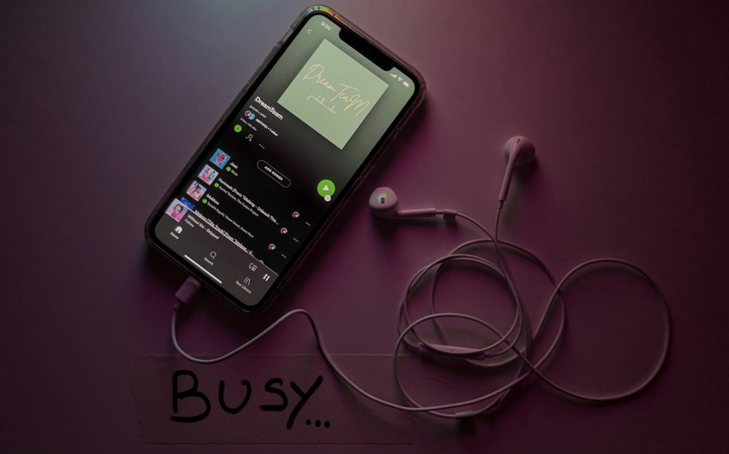 Smartphone displaying Spotify on a white surface